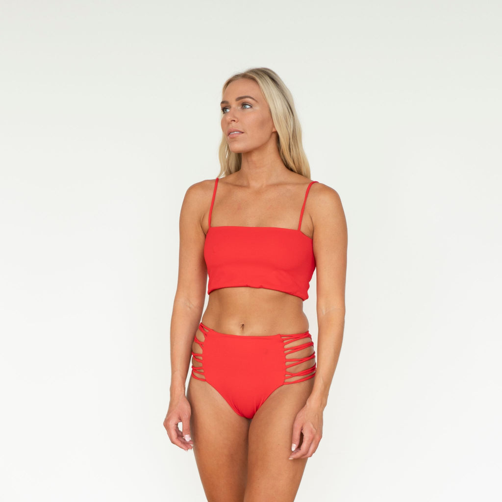 Woman wearing a red bikini set on a white background