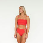 Woman wearing a red bikini set on a white background