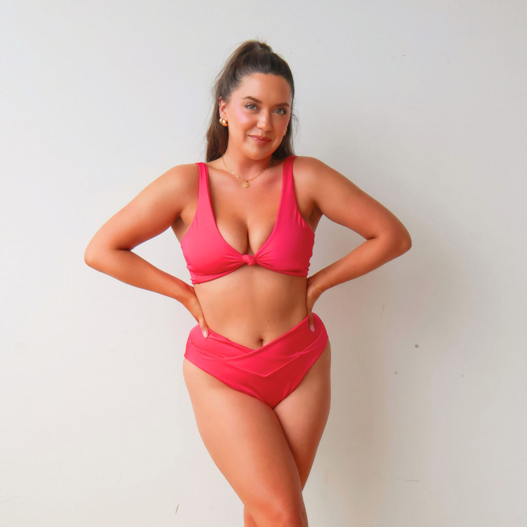 Woman wearing a pink bikini against a plain background